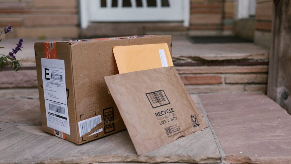 A delivery parcel and envelope left on a doorstep — Royal Mail redelivery scam example