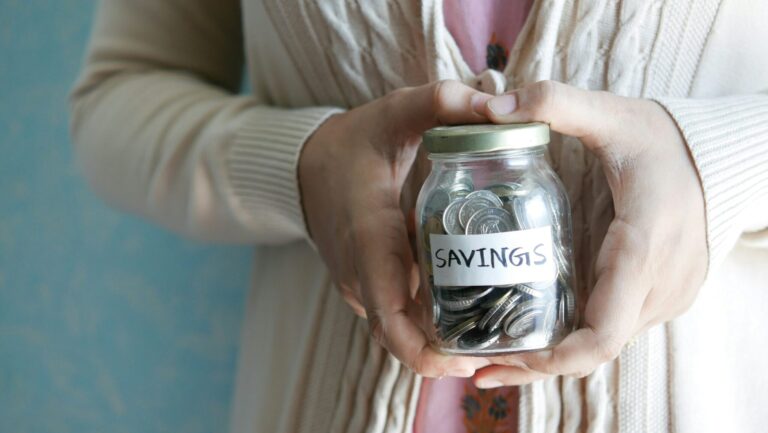 Jar of coins with a symbolising protecting savings from scams.